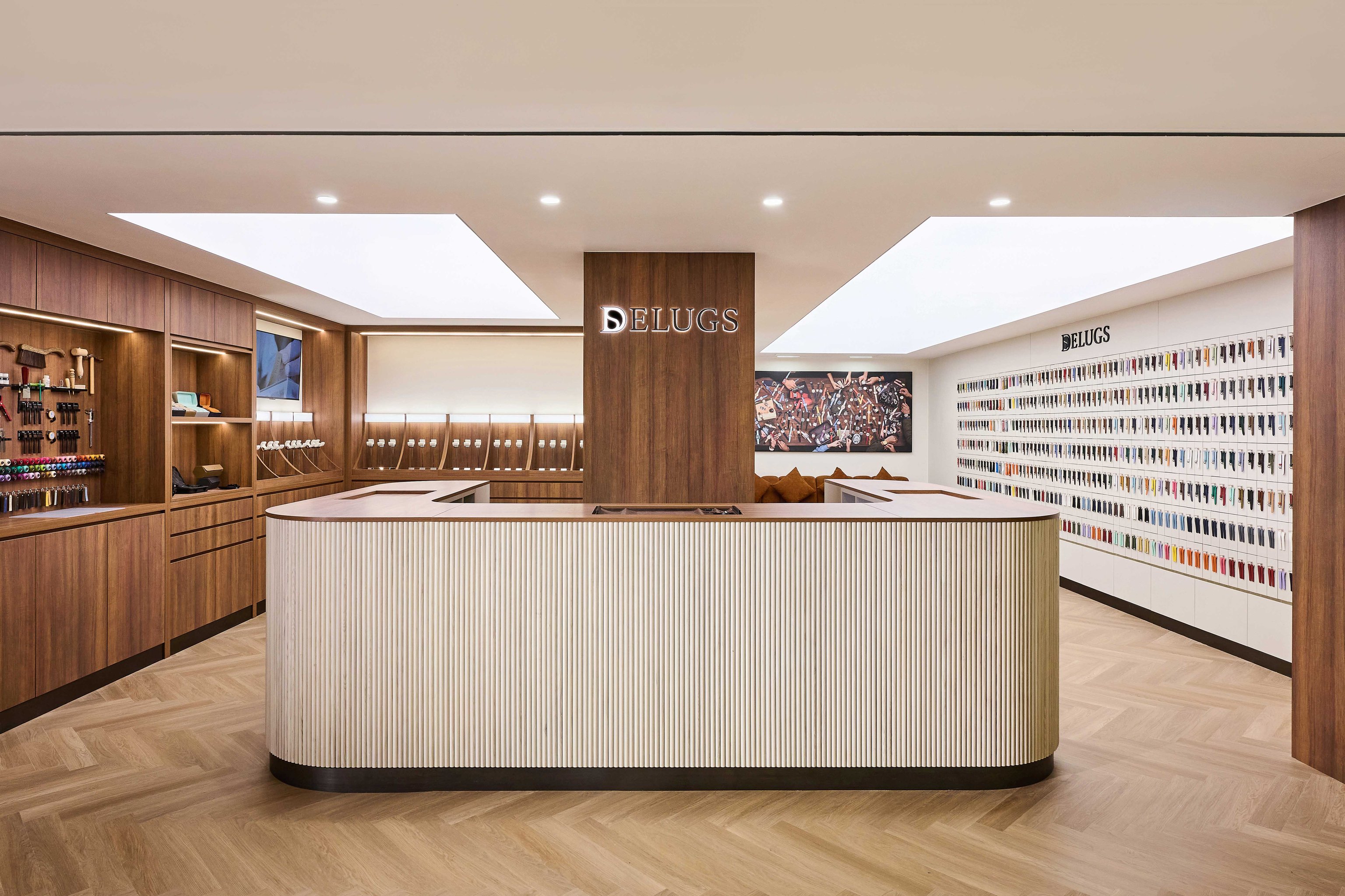 Modern retail store interior with wooden fixtures, a central countertop, shelves of tools, and a colorful array of watch straps on display.